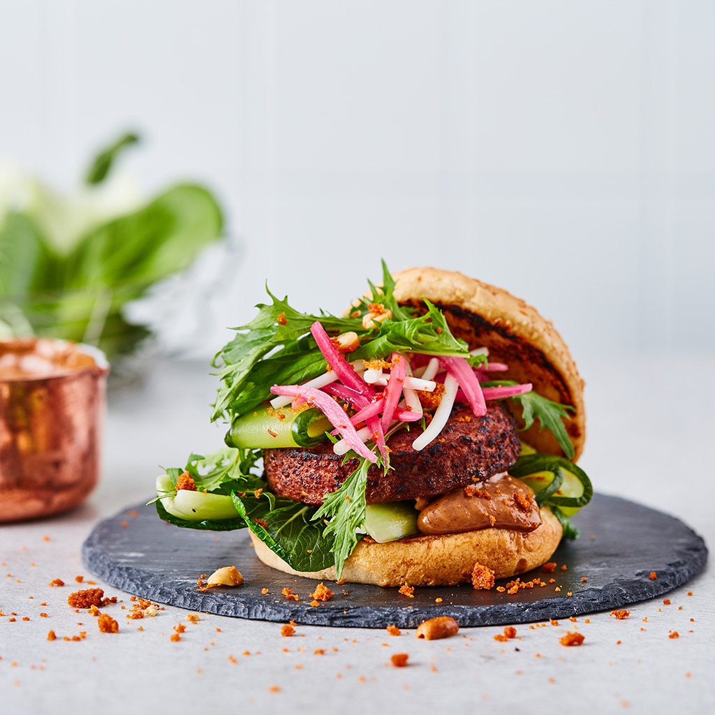Vegetarische burger met zoetzure komkommer, taugé, krokante pinda en satésaus